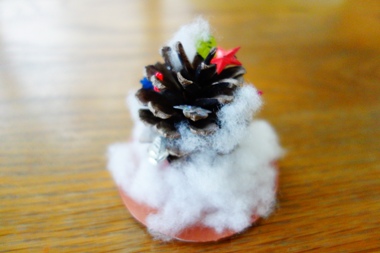 子供が松ぼっくりで作ったクリスマスツリー